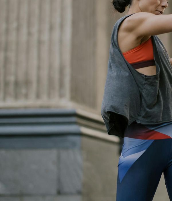 Woman in light activewear performing a gentle cardio movement in a bright, modern studio.